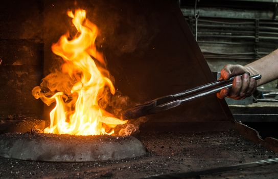 Blacksmith at work, hit with a hammer by a hot metal on the anvil.