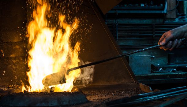 Blacksmith at work, hit with a hammer by a hot metal on the anvil.