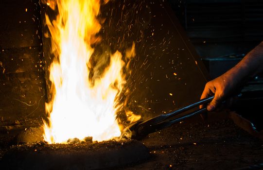 Blacksmith at work, hit with a hammer by a hot metal on the anvil.