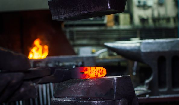 Blacksmith at work, hit with a hammer by a hot metal on the anvil.