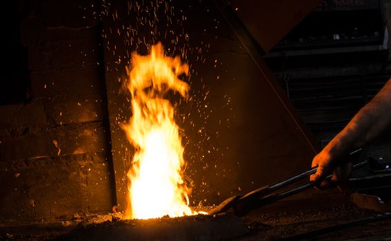 Blacksmith at work, hit with a hammer by a hot metal on the anvil.