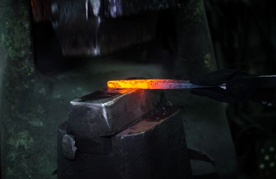 Blacksmith at work, hit with a hammer by a hot metal on the anvil.