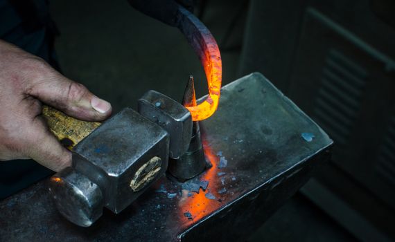 Blacksmith at work, hit with a hammer by a hot metal on the anvil.