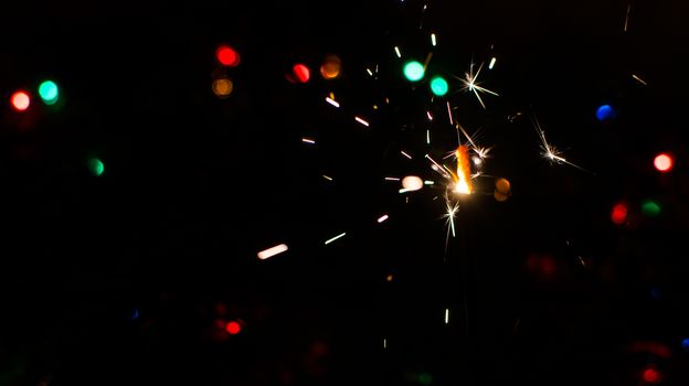 Sparkler and Christmas lights as an ideal background