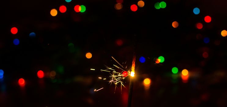 Sparkler and Christmas lights as an ideal background