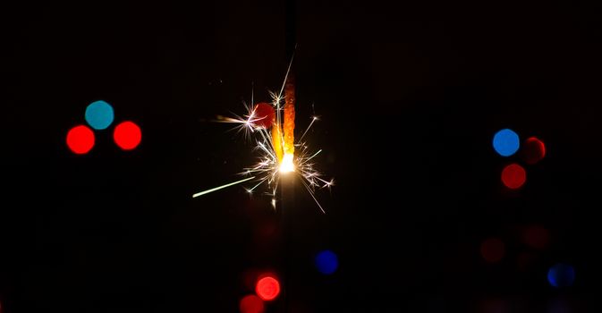 Sparkler and Christmas lights as an ideal background