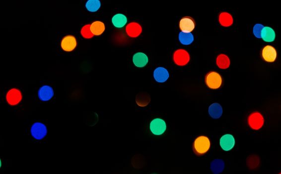 Deliberately blurred Christmas color lights in the background.