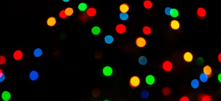 Deliberately blurred Christmas color lights in the background.