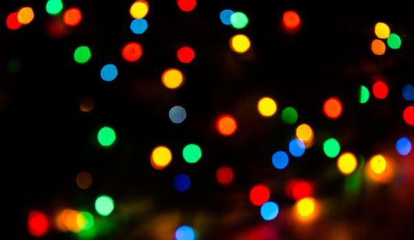 Deliberately blurred Christmas color lights in the background.
