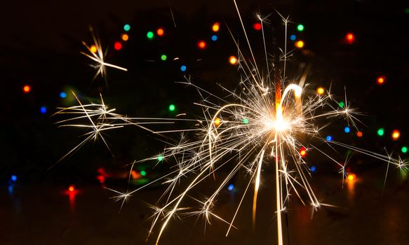 Sparkler and Christmas lights as an ideal background