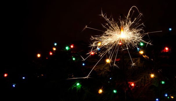 Sparkler and Christmas lights as an ideal background