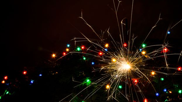 Sparkler and Christmas lights as an ideal background