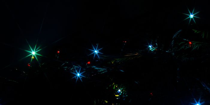 Christmas lights on a tree in different colors are classic symbol of Christmas.