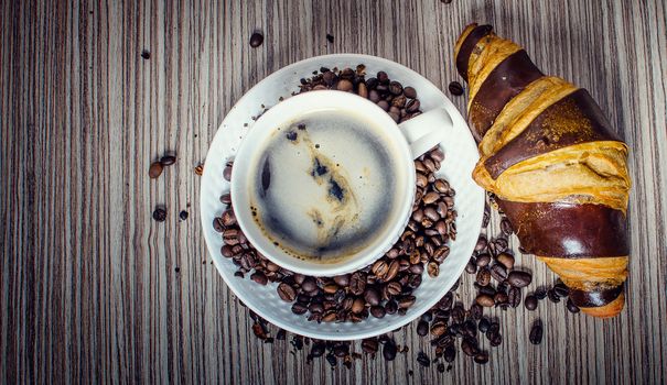 A chocolate croissant with coffee for a hearty breakfast.