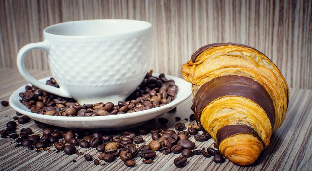 A chocolate croissant with coffee for a hearty breakfast.