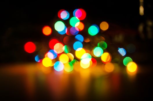 Deliberately blurred Christmas color lights in the background.