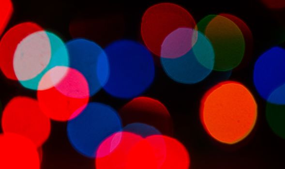 Deliberately blurred Christmas color lights in the background.