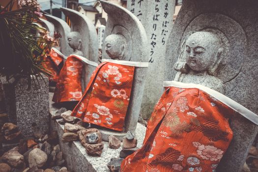 Jizo statues with red bibs in Arashiyama temple, Kyoto, Japan