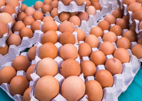 Brown chicken eggs placed in cardboard boxes at the market,outdoor.