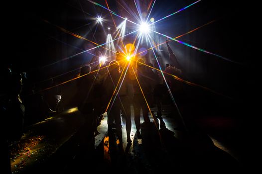 Young dancing people at the party in the shadow.