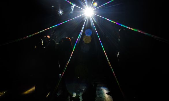 Young dancing people at the party in the shadow.