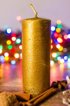Gold candle and different colors lights are classic symbol of Christmas.