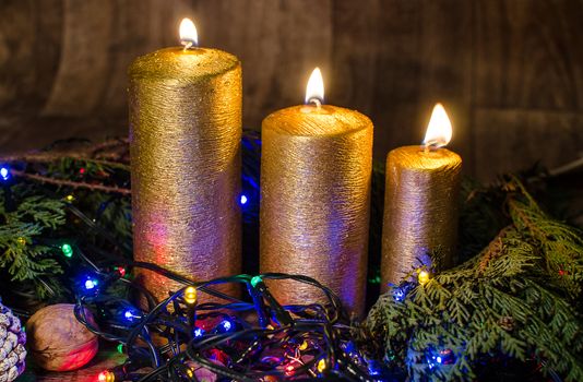 Gold candle and different colors lights are classic symbol of Christmas.