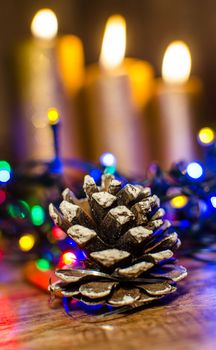 A cone from a tree like a Christmas decoration and a candle background