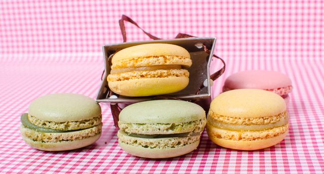Colorful sweet macaroons on retro background.