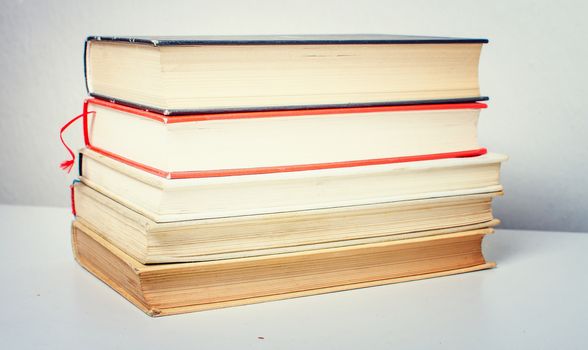 A pile of old, discarded books suited to learning.