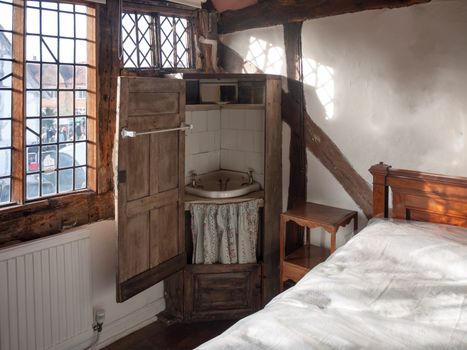 old wooden wash cupboard basin sink closet in corner of english manor house room antique; essex; england; uk
