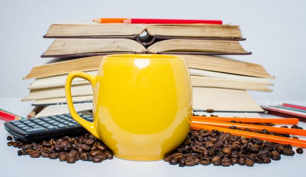 A  pile of books calculator and coffee help in learning.