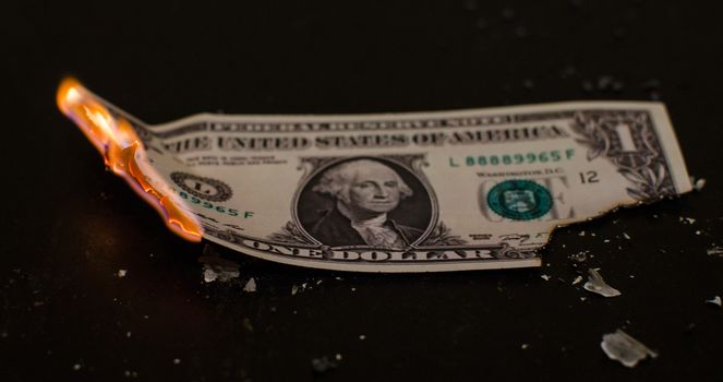 A one dollar bill in American US currency is on fire
