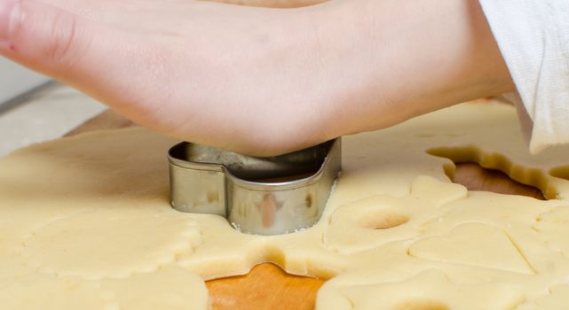 Cutting and baking Christmas cookies in Advent Time.