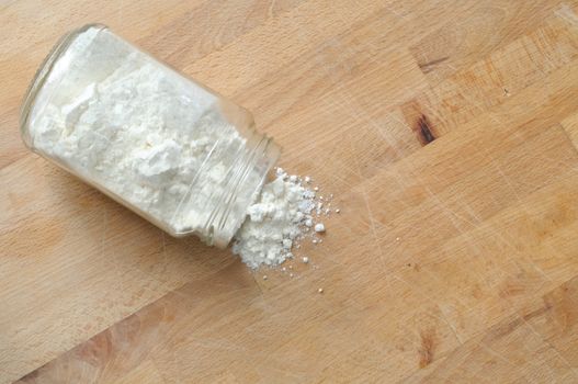 spilled flour from a glass jar, from above, large copy space