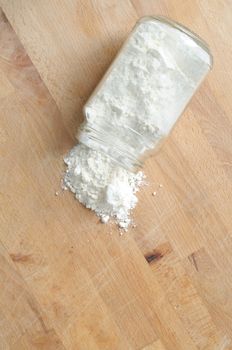 flour on a kitchen wooden board, vertical from above