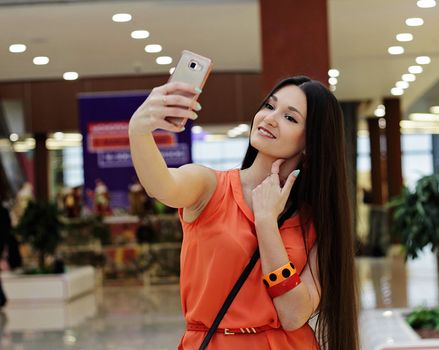 Beautiful Asian girl looks at camera on mobile phone.