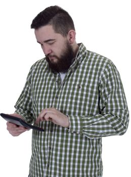 Young bearded man counts on a calculator against a white background