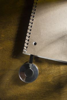 Stethoscope of a doctor in a notebook on a wooden table