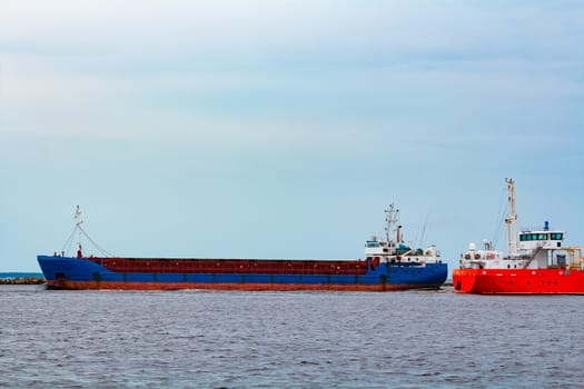 Merchandise import. Large blue cargo ship moving to Riga port