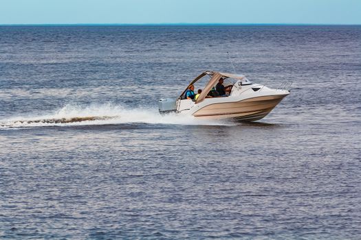 White speed boat moving fast to the Baltic sea. Water sport