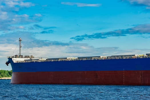 Merchandise import. Large blue cargo ship moving to Riga port