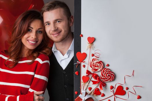 Happy couple posing with Valentine's day decoration with white copy space