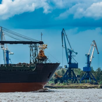 Merchandise import. Large blue cargo ship moving to Riga port