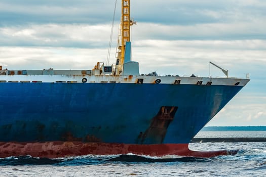 Merchandise import. Large blue cargo ship moving to Riga port