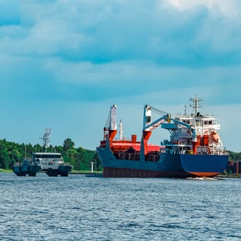 Merchandise import. Large blue cargo ship moving to Riga port