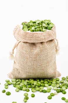 Dried split peas in sack bag on white background.