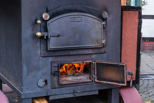 Interior fireplace in a corner with firewood and ax in an old country house