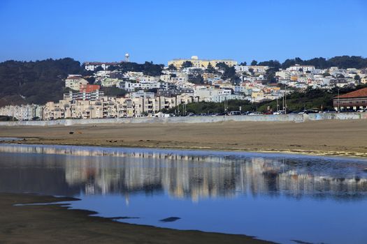 Ocean Beach in San Francisco with reflection of the city on wet sand