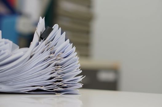 Unfinished document, stacks of paper files with clips on desk for report in the office at morning, Business offices concept on workplace background. 